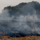 A worker walks through smoke caused by a farming field set on fire to prepare it for its next yield at Chandhat, in the state of Haryana, south of Delhi, India. (Image: AP)
